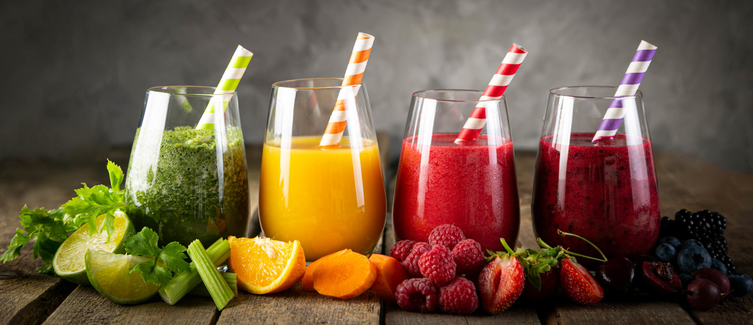 Selection of colorful smoothies in glasses Selection of colorful smoothies and ingredients in glasses, rustic background
